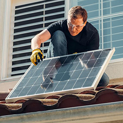 instalador subiendo placa al tejado